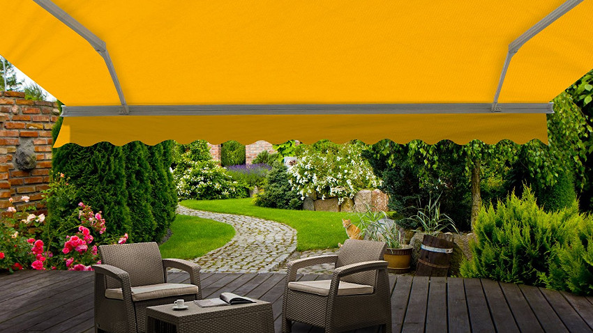 Gelbe markise die sich über Rattan-Gartenmöbel ausstreckt und diese beschützt